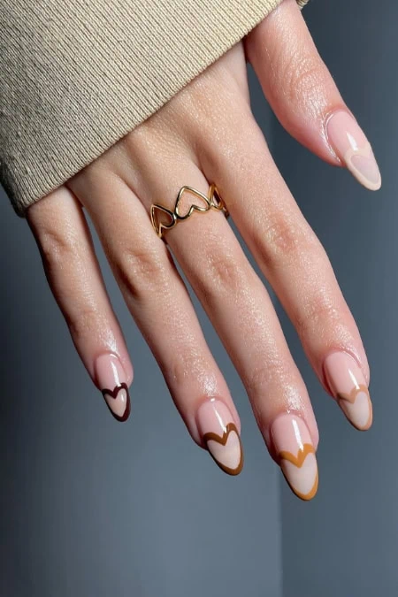 Delicate nail art with heart-shaped designs and gold accents on natural nails, perfect for enhancing beauty and style.
