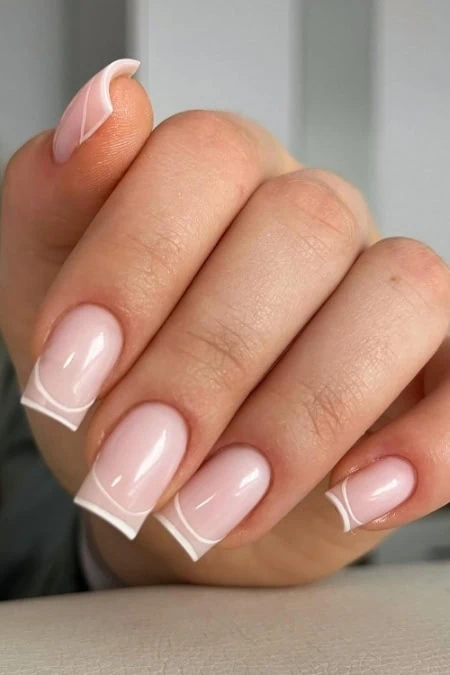 Elegant natural French manicure with glossy finish, perfect for a timeless beauty look.