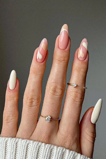 Elegant manicured nails with heart-shaped designs and delicate rings, showcasing modern nail art and jewelry trends. Perfect for beauty, self-care, and stylish accessory inspiration.