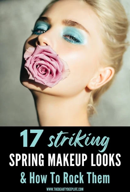 Bright woman with vibrant blue eye makeup holding a pink rose in her mouth, showcasing spring makeup trends and beauty inspiration.