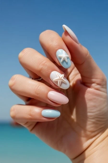 Nail art featuring pastel blue and white colors with starfish designs, perfect for summer or beach vacations.