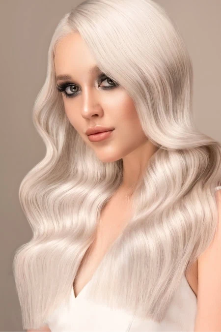 Silky platinum blonde hair styled in soft, flowing waves, showcasing healthy, shiny hair perfect for beauty and hair care enthusiasts.