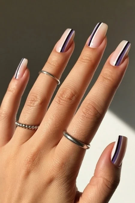 Elegant hand showcasing modern striped nail art with neutral tones and metallic accents, perfect for a chic and sophisticated square nails look.