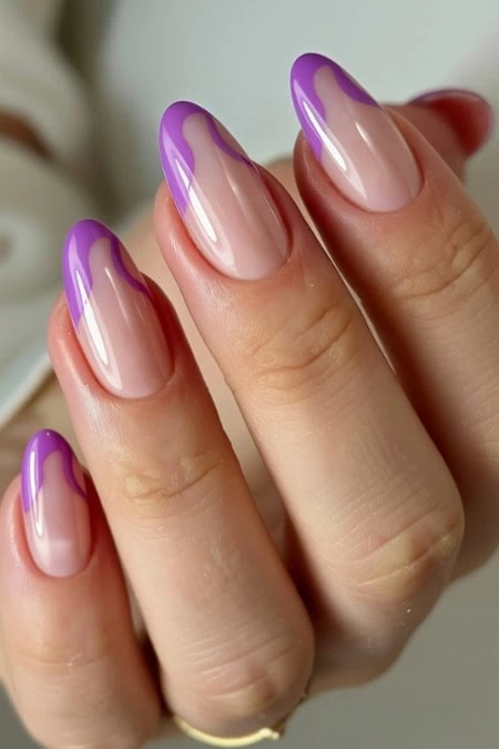 Woman's hand showcasing a stylish purple French manicure with glossy finish and natural nail base. Perfect for nail art enthusiasts and beauty lovers.