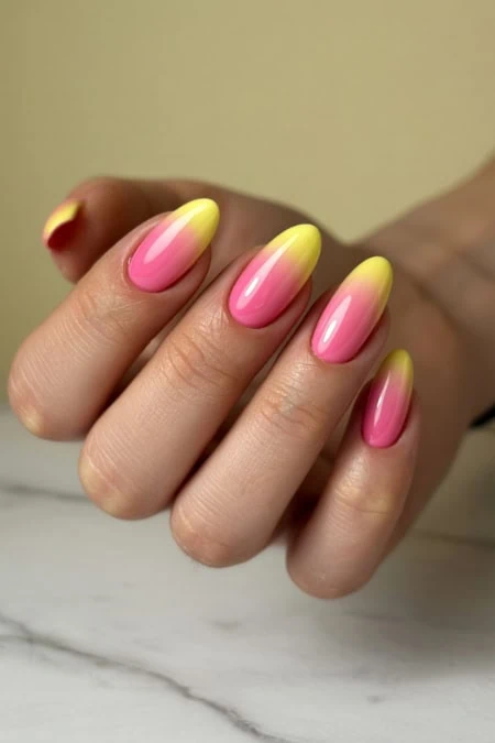 Beautiful pastel ombre nails featuring a smooth transition from pink to yellow, showcasing a trendy and stylish manicure perfect for spring and summer.