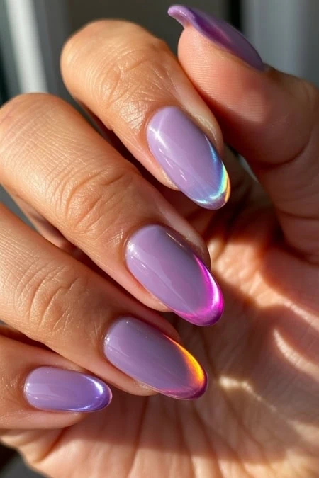 Elegant lavender manicure with iridescent, holographic accents on almond-shaped nails, showcasing a trendy and sophisticated nail design perfect for beauty and fashion enthusiasts.