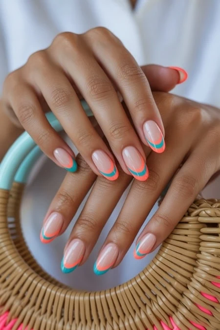Elegant nail art featuring a clear base with vibrant turquoise and coral accents, perfect for summer or special occasions.