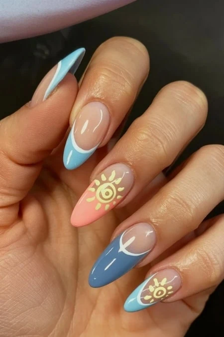 Nail art featuring pastel blue and pink colors with sun and moon motifs, showcasing creative and stylish nail designs perfect for beauty and fashion enthusiasts.