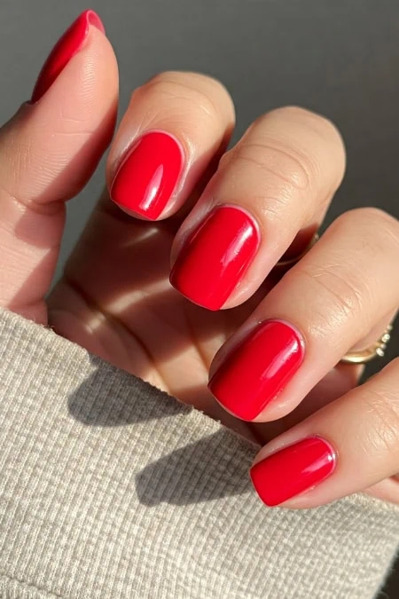 Elegant red manicure with glossy finish on neatly shaped nails.