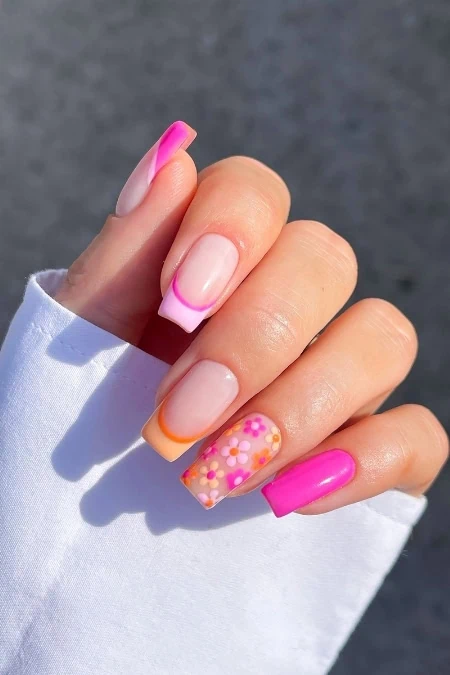Colorful spring nail art featuring pink, orange, and floral patterned square nails, showcasing creative and vibrant manicure designs perfect for the season.