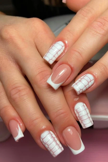 Elegant French manicure with square nails and white checkered accents on well-groomed hands, showcasing professional nail art and perfect grooming, ideal for beauty and nail care enthusiasts.