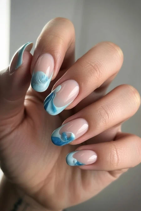 Beautiful marble nail art featuring blue and white swirls on natural nails, perfect for fashion-forward individuals seeking unique and artistic manicure styles.