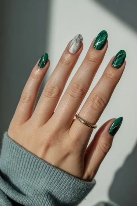 Beautiful manicured hand showcasing green and silver nail polish with gold ring, emphasizing stylish and trendy nail art design for beauty and self-care.