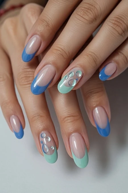 Beautiful manicure featuring blue and mint nail polish with decorative pearls, showcasing stylish and trendy nail art design.