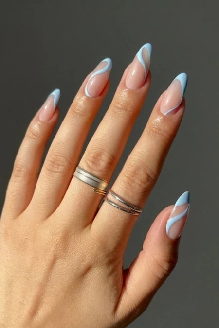 Stylish French manicure with abstract light blue tips on a well-manicured hand, featuring rings, perfect for beauty, nails, and self-care themes.