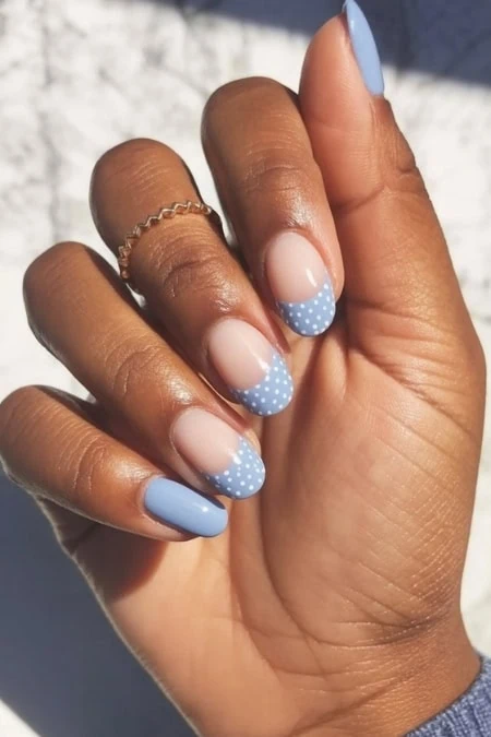 Beautiful hand with light blue and white polka dot nails design, showcasing trendy and stylish manicure perfect for beauty and self-care enthusiasts.