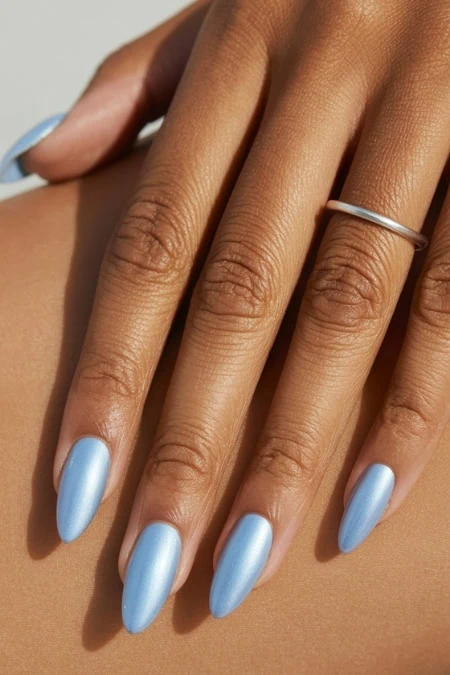 Elegant blue nail polish manicure featuring a silver ring on the finger, highlighting beauty and self-care. Perfect for showcasing nail art, hand beauty, and personal grooming.
