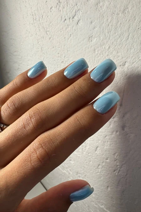 Beautiful manicure featuring light blue nail polish on neatly shaped nails, showcasing a clean and elegant look suitable for beauty and self-care themes.