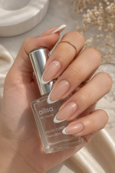 A woman’s hand holding a clear nail polish bottle with a silver cap, showcasing well-manicured, glossy, natural-looking nails, with a soft beige and neutral background emphasizing beauty and nail care.
