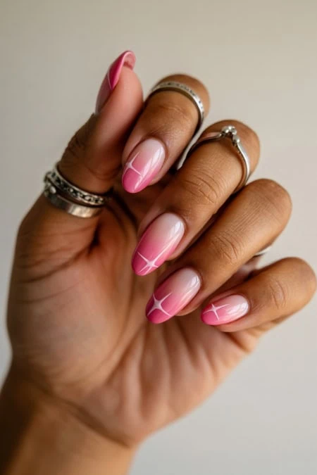 Elegant hand with manicured nails featuring pink and white French tips, adorned with multiple silver rings, showcasing beauty and self-care, perfect for a beauty, nail art, or lifestyle website.
