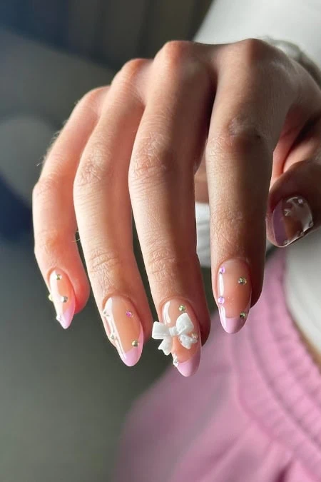 A beautiful hand with manicured nails featuring pink and white nail art with 3D floral accents, showcasing elegant and creative nail design for beauty and self-care.
