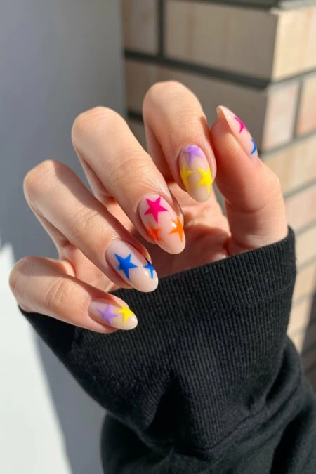 Brightly colored star nail art with multicolor stars on almond-shaped nails, showcasing trendy and playful manicure design for beauty and fashion enthusiasts.