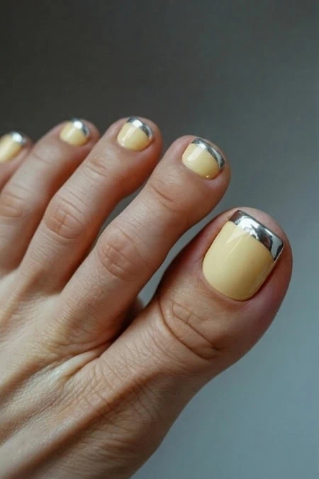 Beautiful manicured nails featuring a beige base with silver metallic tips, showcasing a chic and modern nail design perfect for stylish and sophisticated looks.