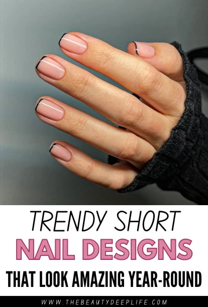 Close-up of a woman's hand with trendy short nail designs featuring nude polish and black accents, showcasing stylish nail art for a modern look.