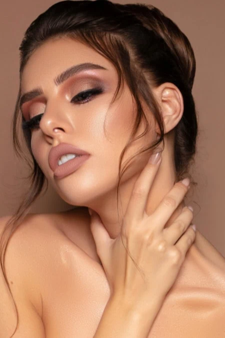 Close-up of a woman with flawless makeup, styled hair, and elegant pose, showcasing eye makeup and fall looks.