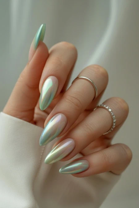 Elegant green nails with an iridescent finish on a woman's hand, showcasing a manicure perfect for all-year-round style.