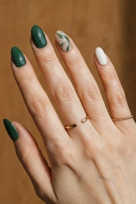 Elegant green and white marbled nail art on well-manicured fingers, perfect for all-year-round style.