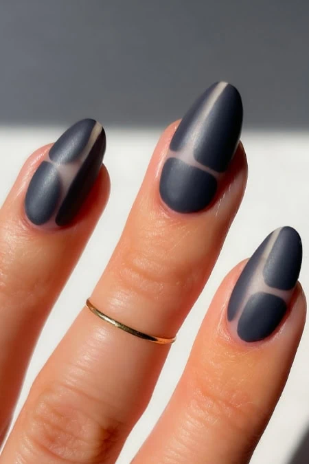 Close-up of stylish matte gray nail art with geometric design on well-manicured fingers, showcasing modern beauty and nail art trends.
